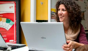 woman with laptop smiling learnimg spanish online